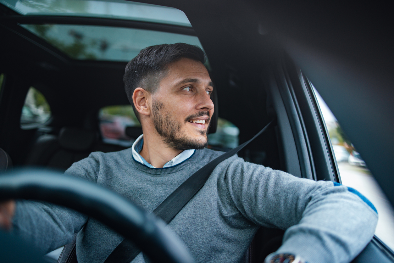 A man driving a car and smiling