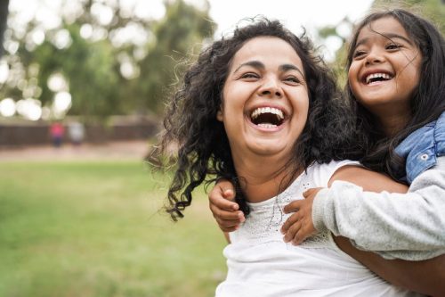 mother and daughter laughing outside