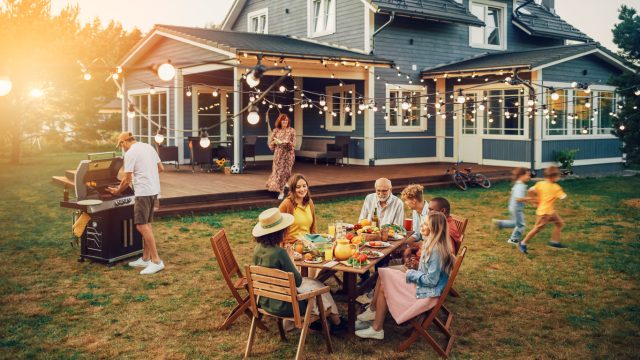 A family having an outdoor dinner party in their backyard