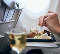 Close-up of a person eating an in-flight meal on an airplane