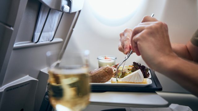 Close-up of a person eating an in-flight meal on an airplane