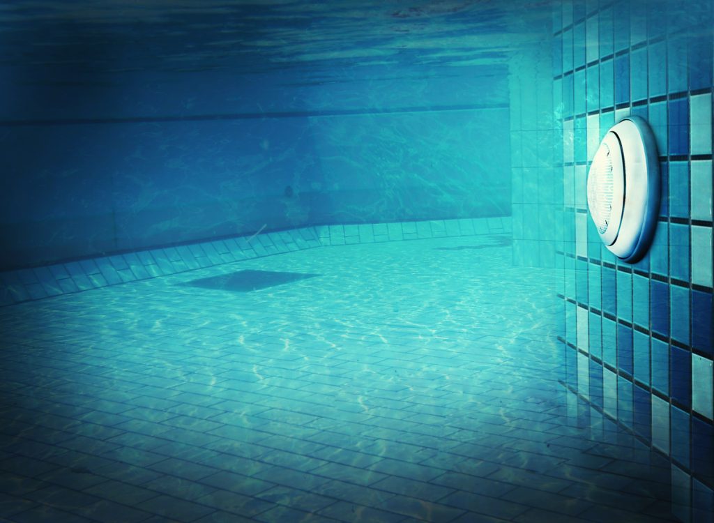 An underwater photo of a pool light at night