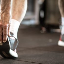 Closeup of a senior man grabbing his sneaker, stretching his legs