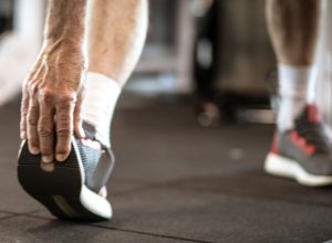 Closeup of a senior man grabbing his sneaker, stretching his legs