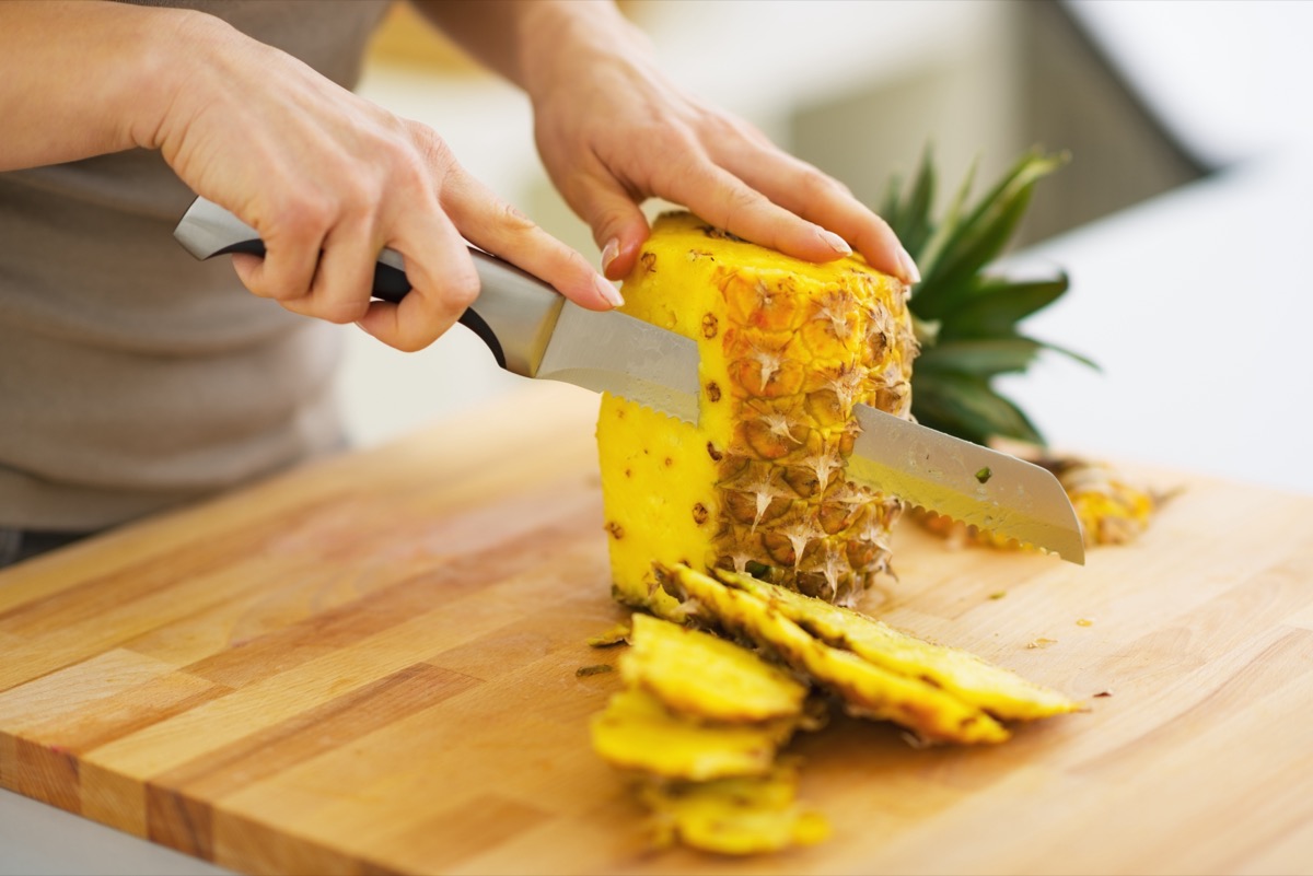 woman cutting pineapple