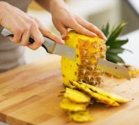 woman cutting pineapple