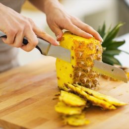 woman cutting pineapple