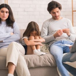 Unhappy child with parents in family therapy