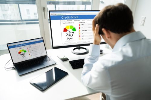 man disappointed looking at credit score on computer