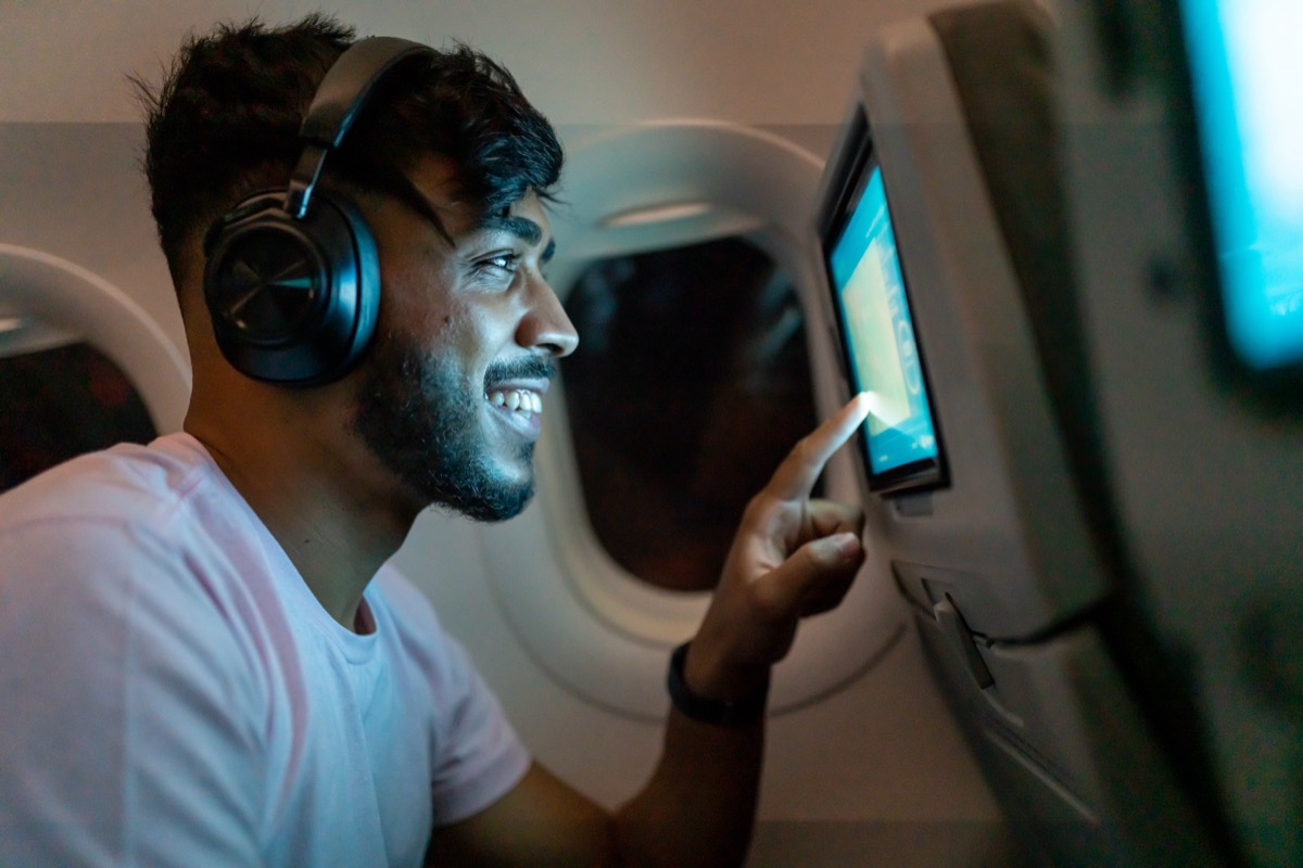 happy passenger using in-flight entertainment system
