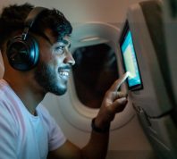 happy passenger using in-flight entertainment system