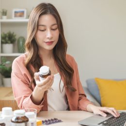 young woman inspecting a bottle of supplements