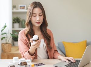 young woman inspecting a bottle of supplements