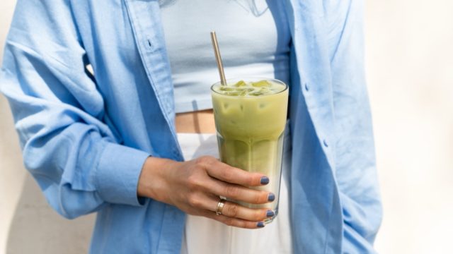 woman holding iced matcha latte