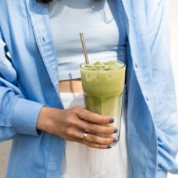 woman holding iced matcha latte