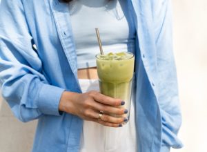 woman holding iced matcha latte