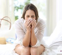 sick woman coughing in a hotel room while on a summer vacation