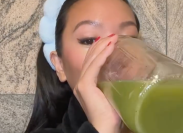 still from a video of a young woman drinking celery juice