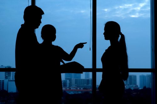 Silhouettes of parents arguing with their teenage daughter