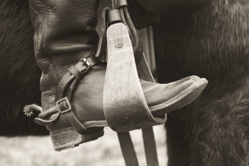 sepia photo of cowboy boot in a spur