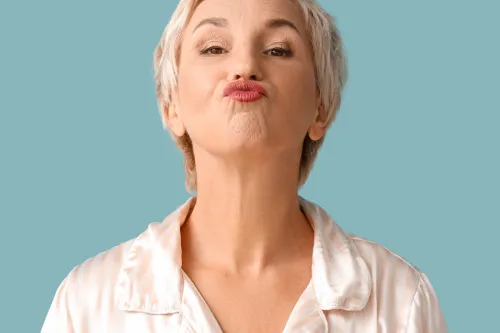 mature woman doing face building exercise on blue background