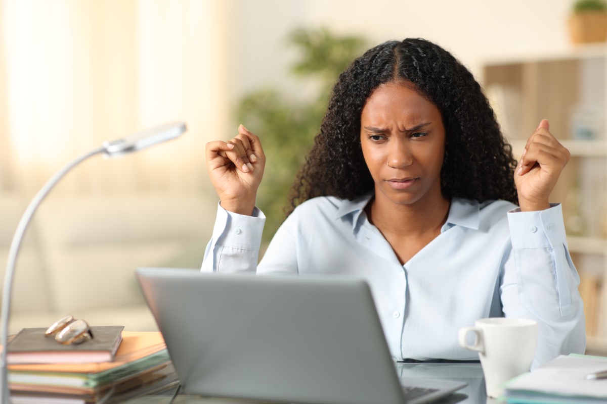 woman looking suspiciously at her laptop scream