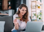 A woman shopping online with her laptop while holding her credit card