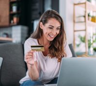 A woman shopping online with her laptop while holding her credit card