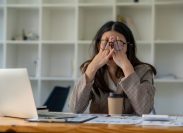 businesswoman stressed in front of her computer in an office with coffee