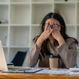 businesswoman stressed in front of her computer in an office with coffee