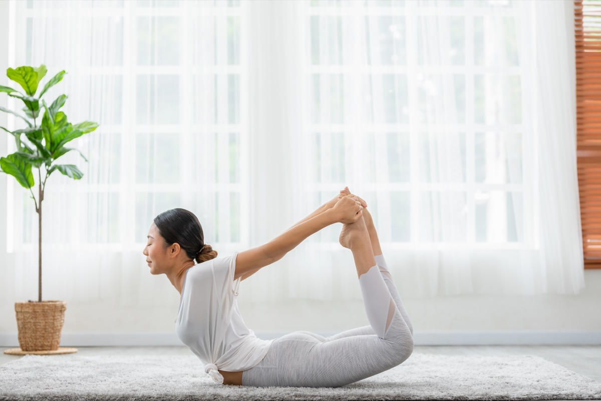 Young woman doing bow pose in yoga