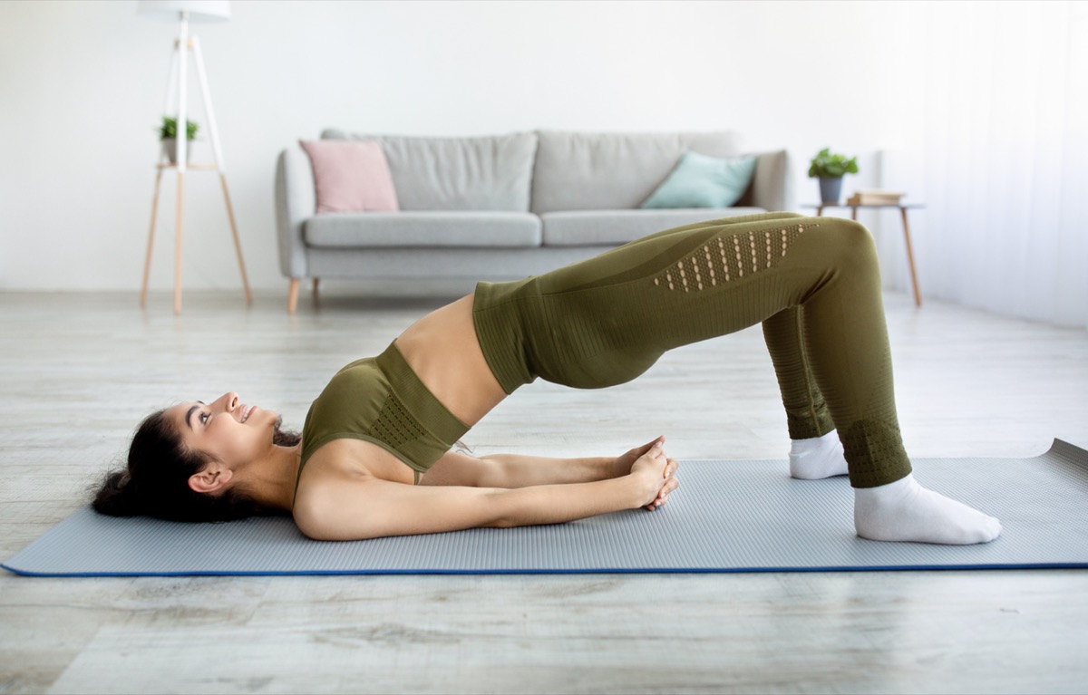 Young woman doing bridge pose yoga