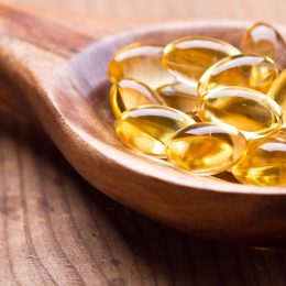Cod liver oil omega 3 gel capsules isolated on wooden background