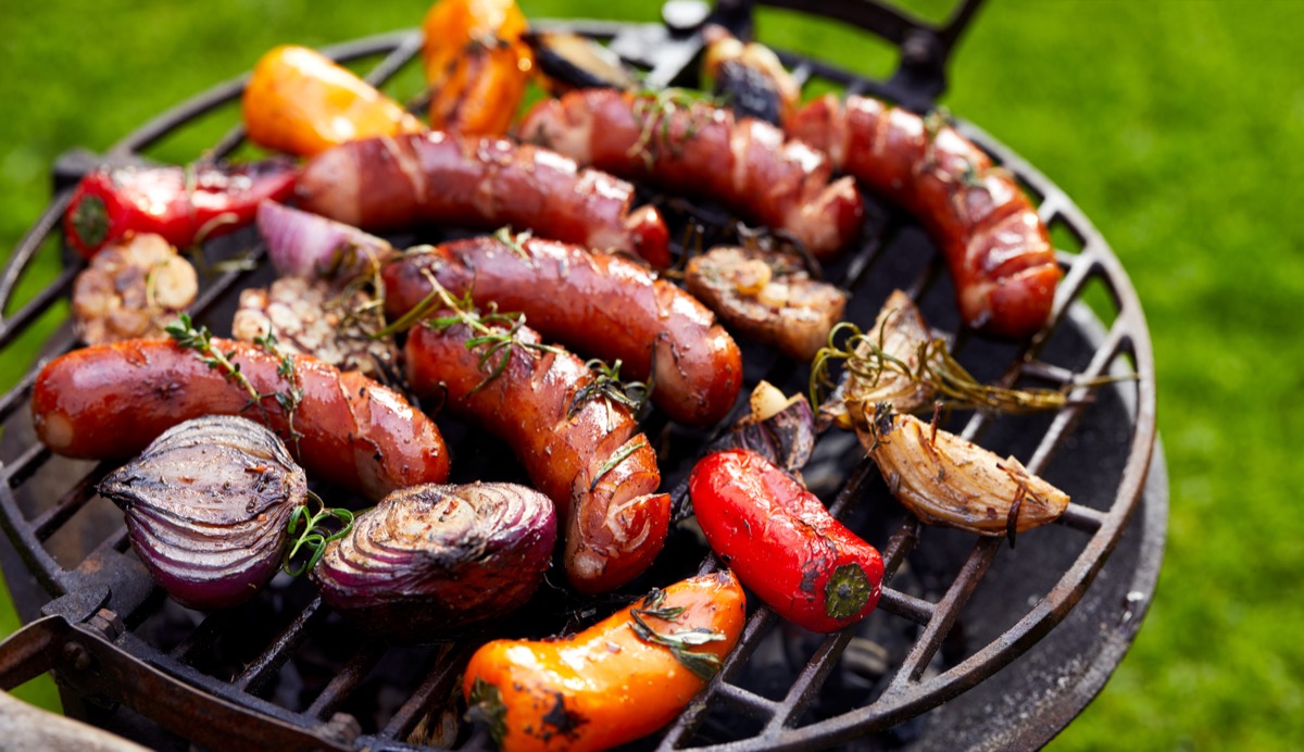 Grilled sausages and vegetables on a grilled plate, outdoor. Grilled food, bbq