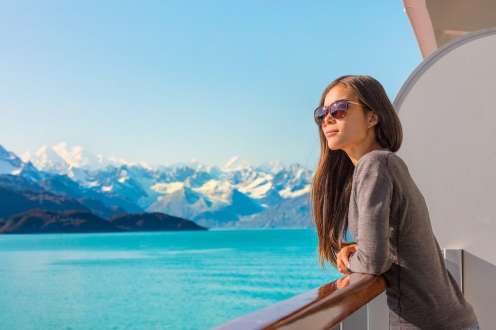 Aoman relaxing on cruise ship balcony looking at view of mountains and nature landscape
