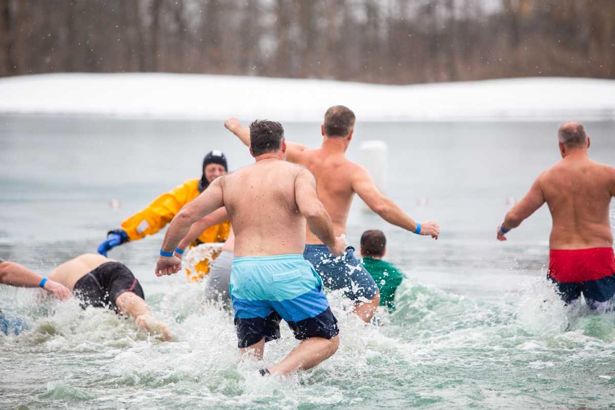 People running into the ocean for a cold plunge