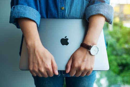 Closeup of woman holding Mac computer
