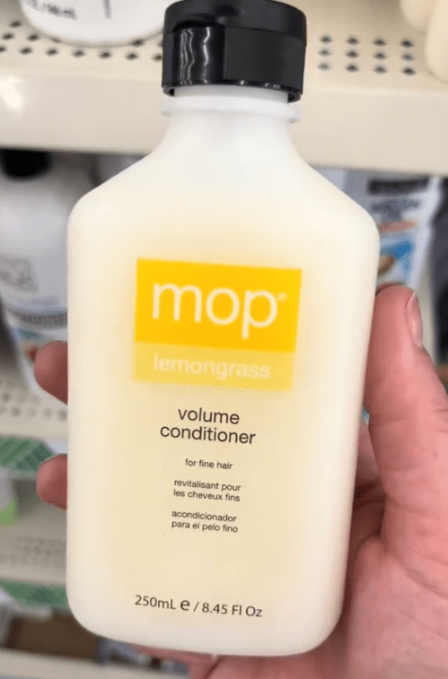 shopper holding up mop hair conditioner at Dollar Tree