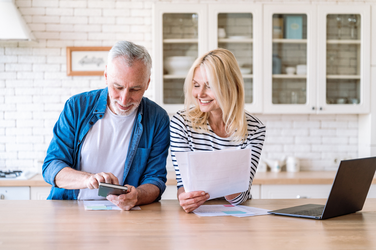 A senior couple looking at their finances in a kitchen