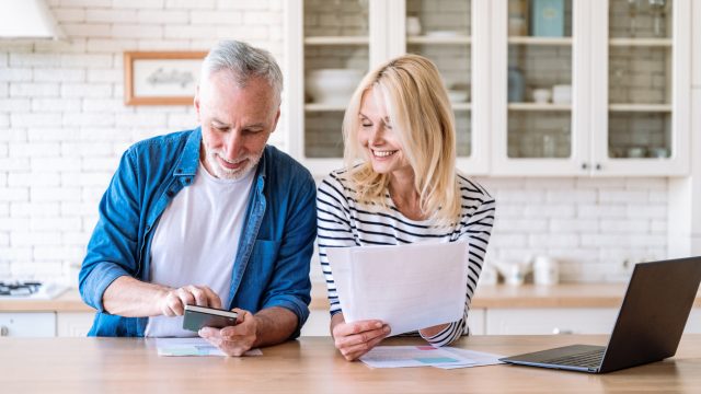 A senior couple looking at their finances in a kitchen