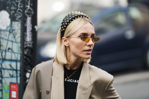 Woman wearing Balenciaga shirt, studded headband, and tiny sunglasses