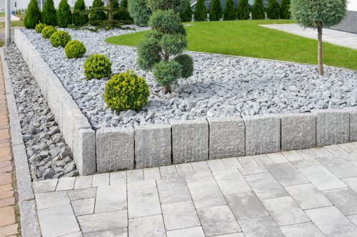 Closeup of a gray stone driveway with a matching retaining wall