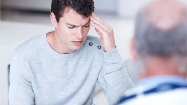 man talking to doctor about headache