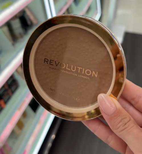 Shopper holding up Make Revolution bronzer at Target