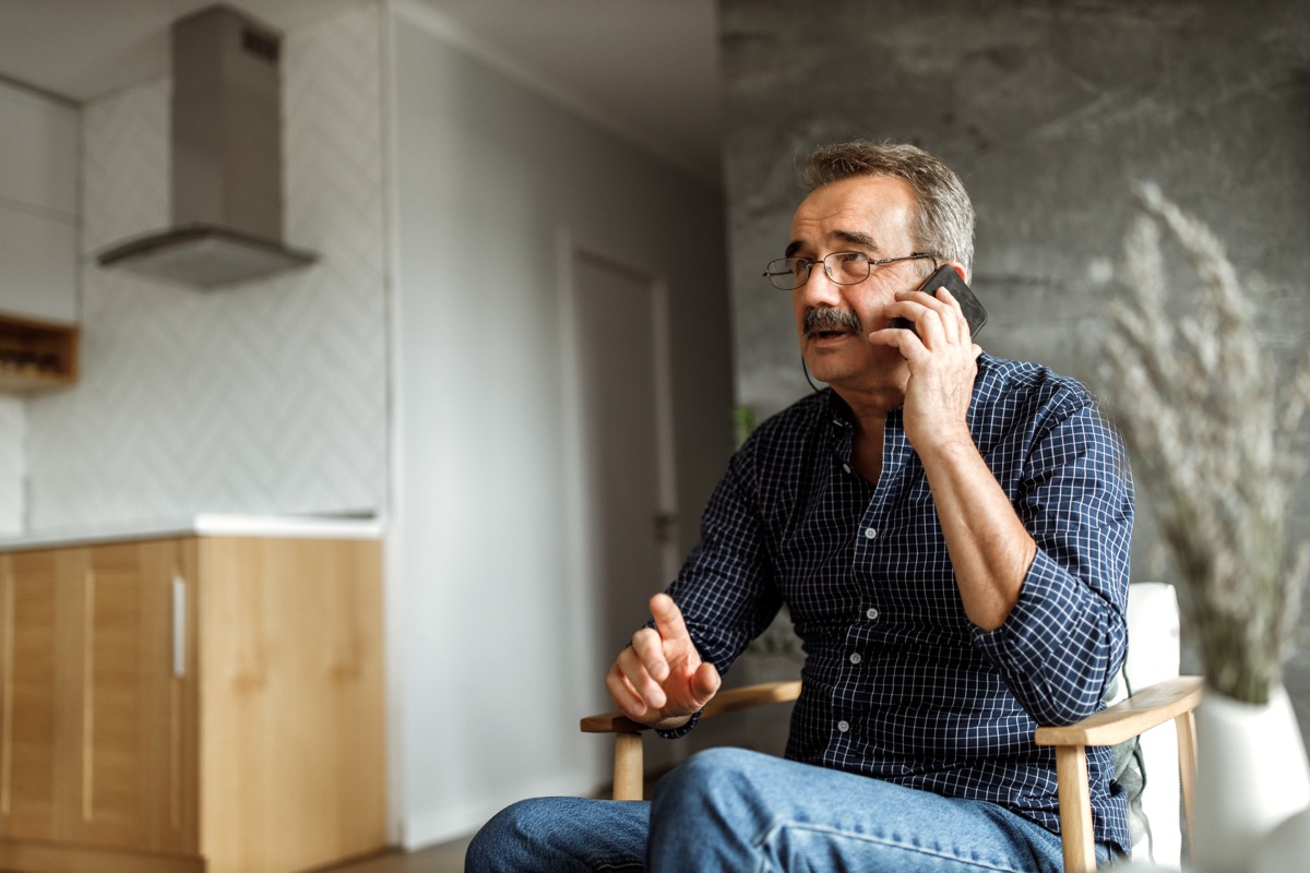 older man talking on phone