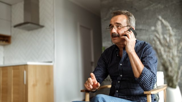 older man talking on phone