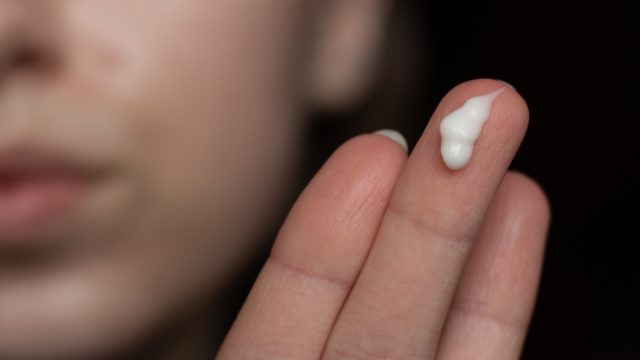 woman with retinoid cream on her fingers