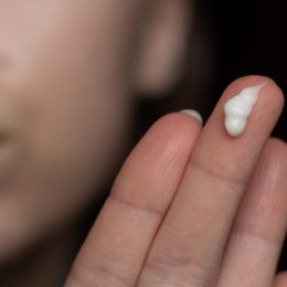 woman with retinoid cream on her fingers