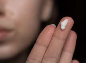 woman with retinoid cream on her fingers