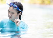 teenage girl swimming in pool with water in her ear
